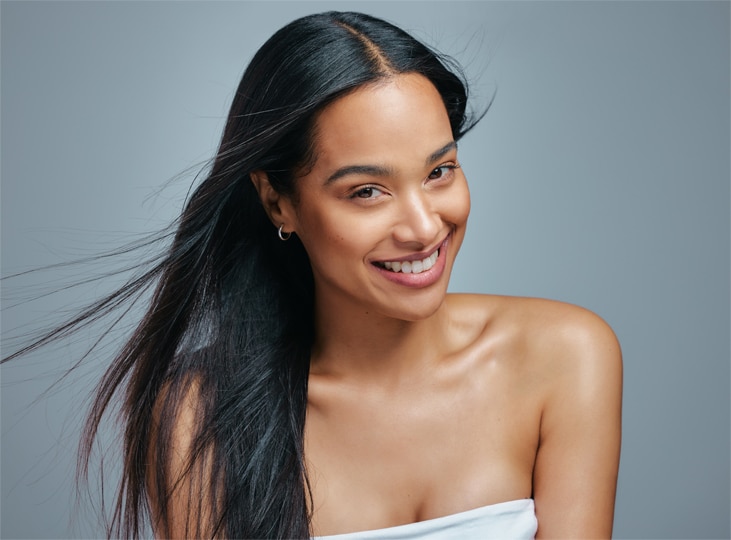 Smiling woman with long dark hair in a studio portrait