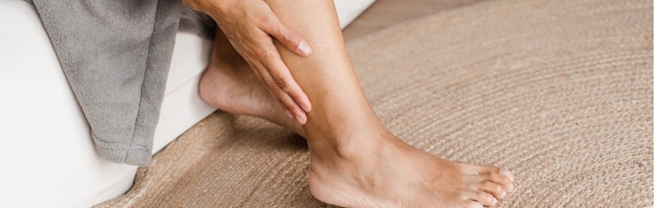 deep vein thrombosis and varicose of african woman girl touching her legs and looking at