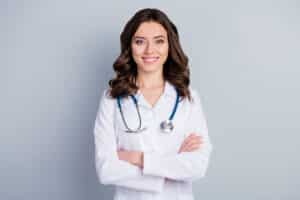 Smiling woman doctor in a white coat with a stethoscope