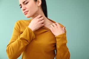 Woman scratching her neck in discomfort from a rash in Los Angeles, CA